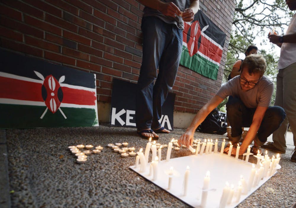 <p>Ph.D. student and Department of Environmental and Global Health research coordinator John Anderson, 34, lights a candle dedicated to Kenya mall-shooting victims on Turlington Plaza Monday.</p>