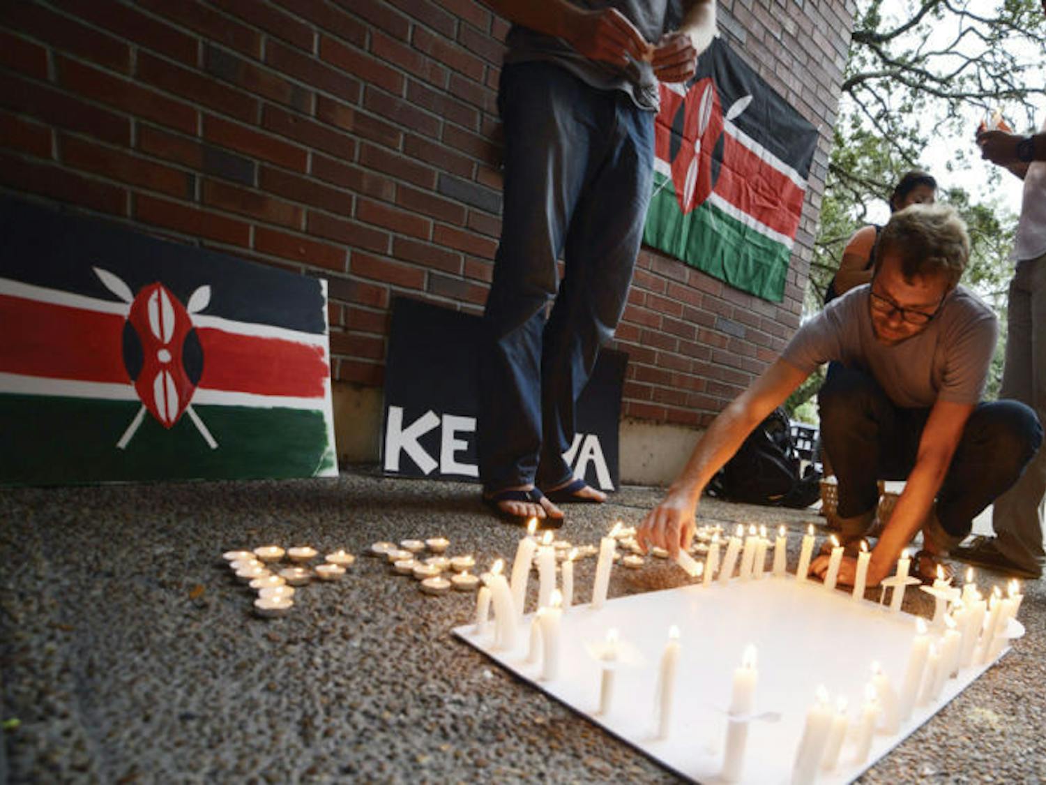 Ph.D. student and Department of Environmental and Global Health research coordinator John Anderson, 34, lights a candle dedicated to Kenya mall-shooting victims on Turlington Plaza Monday.