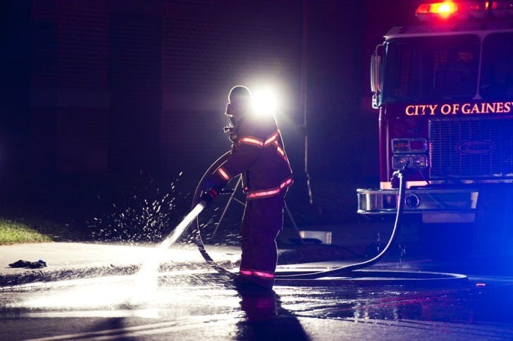 A firefighter hoses down Union Road after a chemical reactant explosion at Sisler Hall on Wednesday evening.