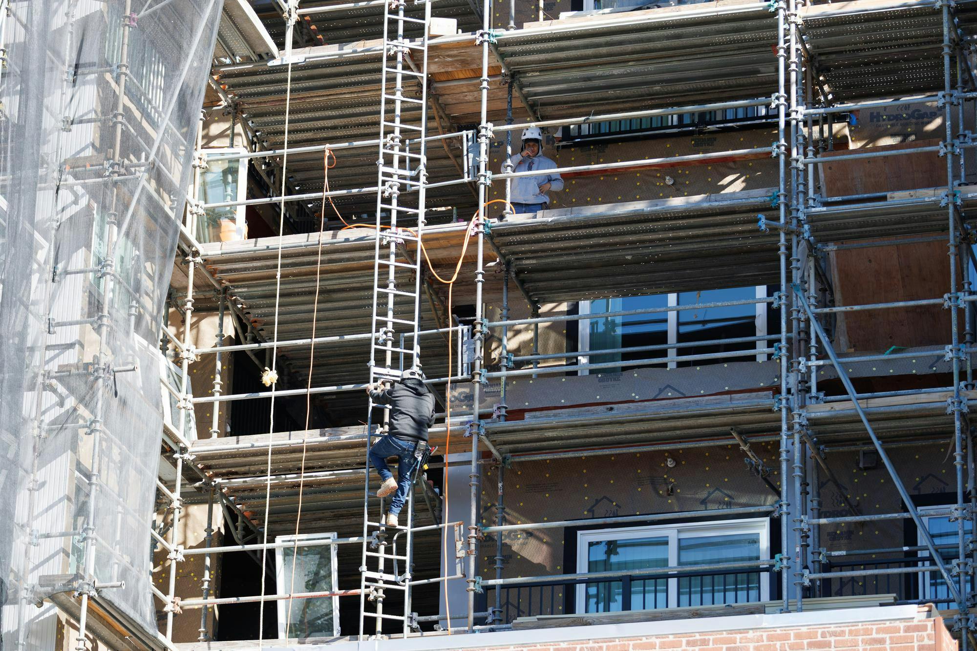 Construction workers work on the south building of the Social 28 apartment complex in Gainesville, Fla., Monday, Feb. 23, 2026.