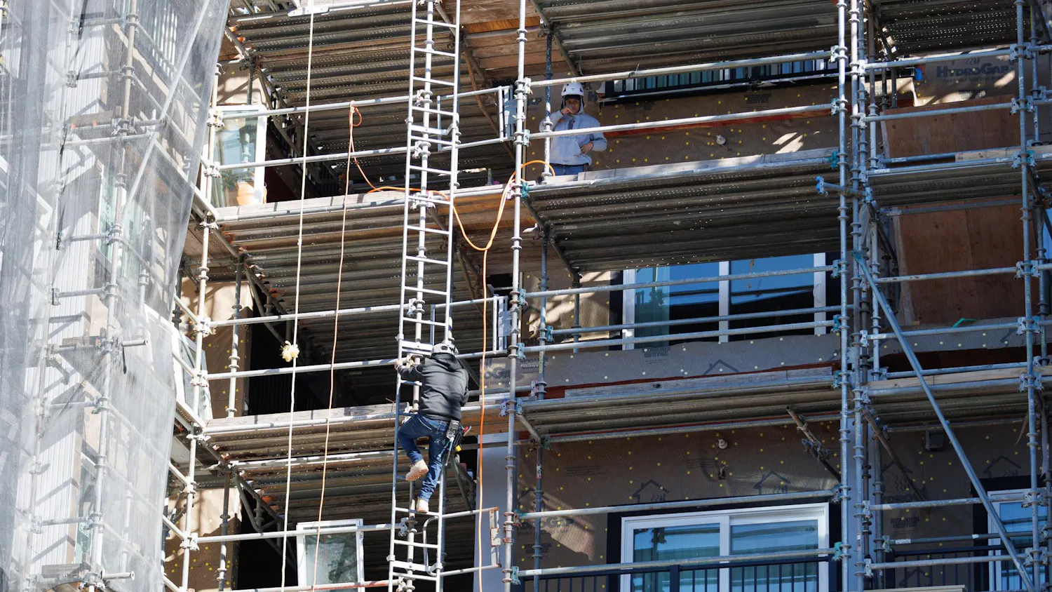 Construction workers work on the south building of the Social 28 apartment complex in Gainesville, Fla., Monday, Feb. 23, 2026.