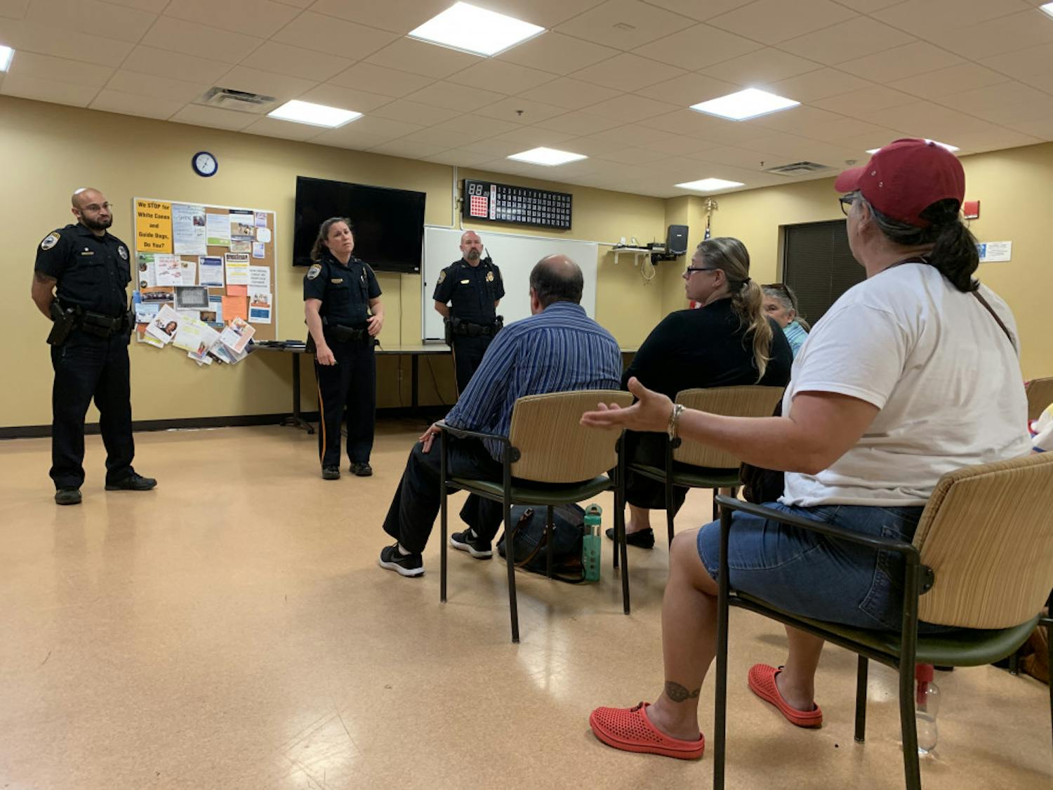 Gainesville resident Elizabeth Carrillo, 56, talks about recent dog attacks to three Gainesville Police officers at a neighborhood meeting Tuesday night.