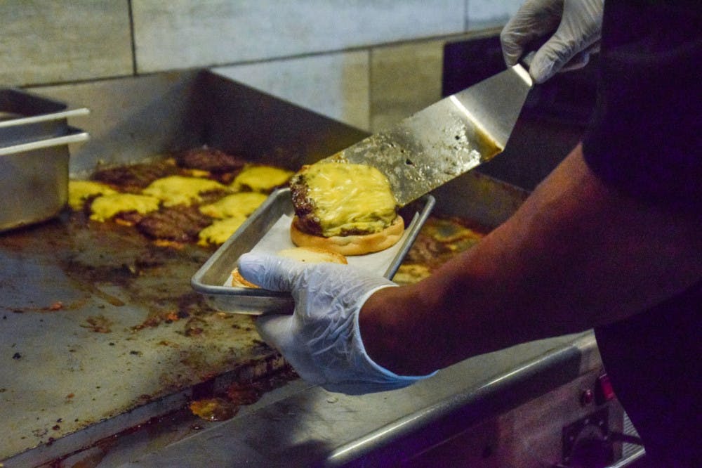 <p>An employee prepares a cheeseburger at The Fresh Food Company.</p>