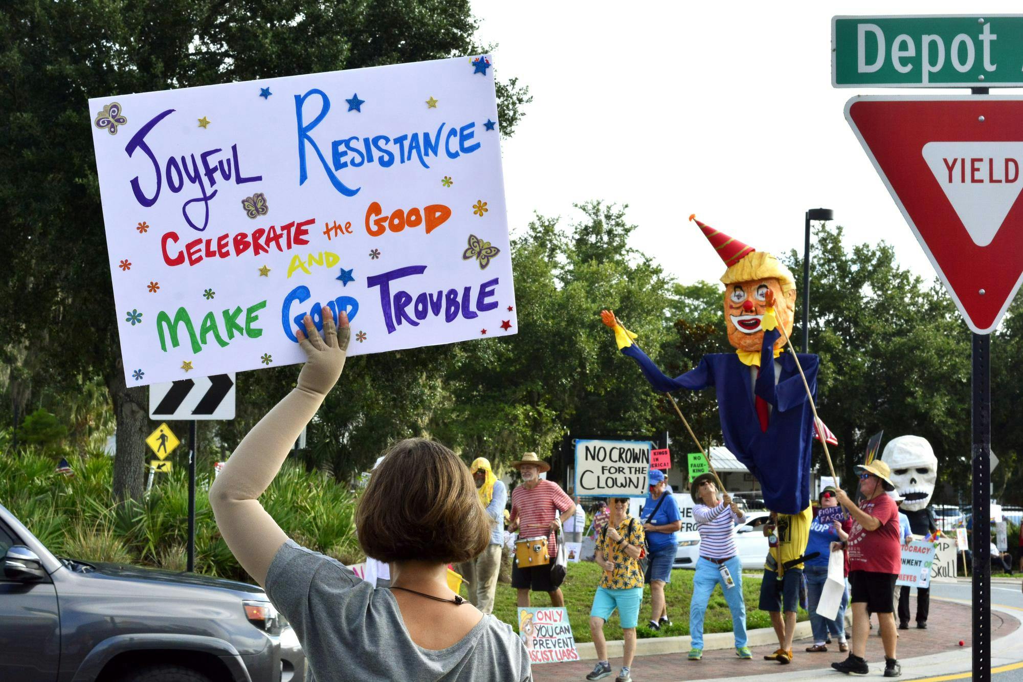 A protester carries a sign as the crowd chants at Depot Park on Friday, July 4, 2025. 