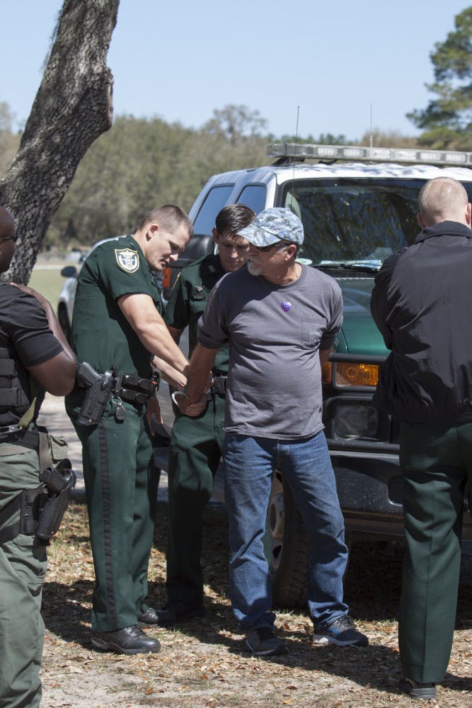A man is handcuffed after allegedly punching another man in the face and knocking him unconscious after Town Hall with Congressman Ted Yoho at Countryside Baptist Church on Saturday, March 4, 2017. Witnesses said they saw the man throw the punch after an exchange of words and walked back into the crowd.