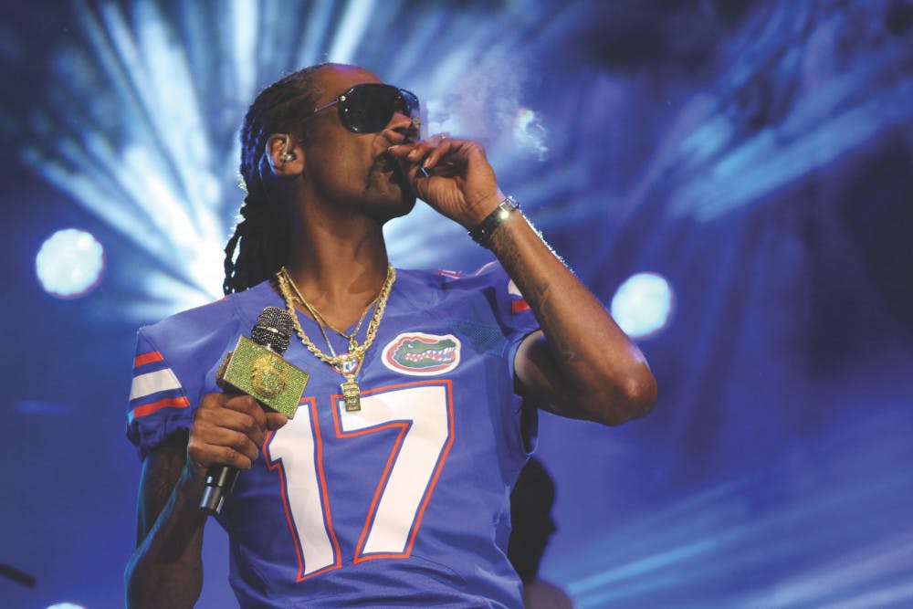 Rapper Snoop Dogg smokes onstage while wearing a Gators jersey at Gator Growl on Flavet Field on Friday.