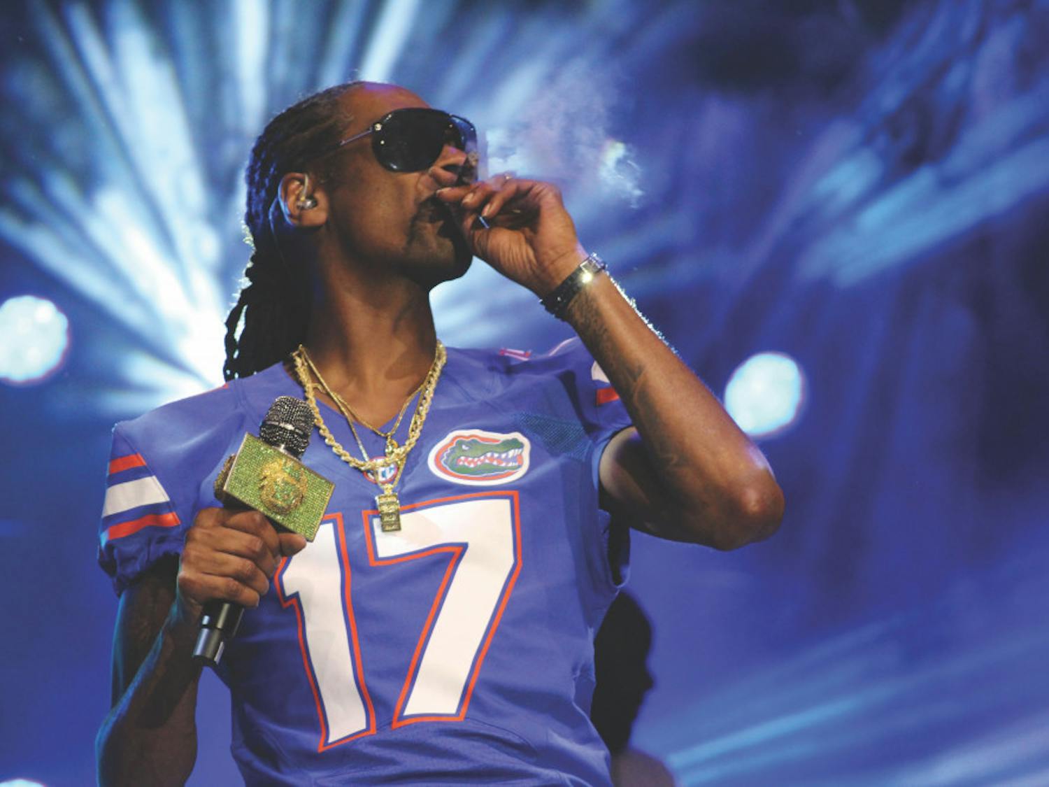 Rapper Snoop Dogg smokes onstage while wearing a Gators jersey at Gator Growl on Flavet Field on Friday.