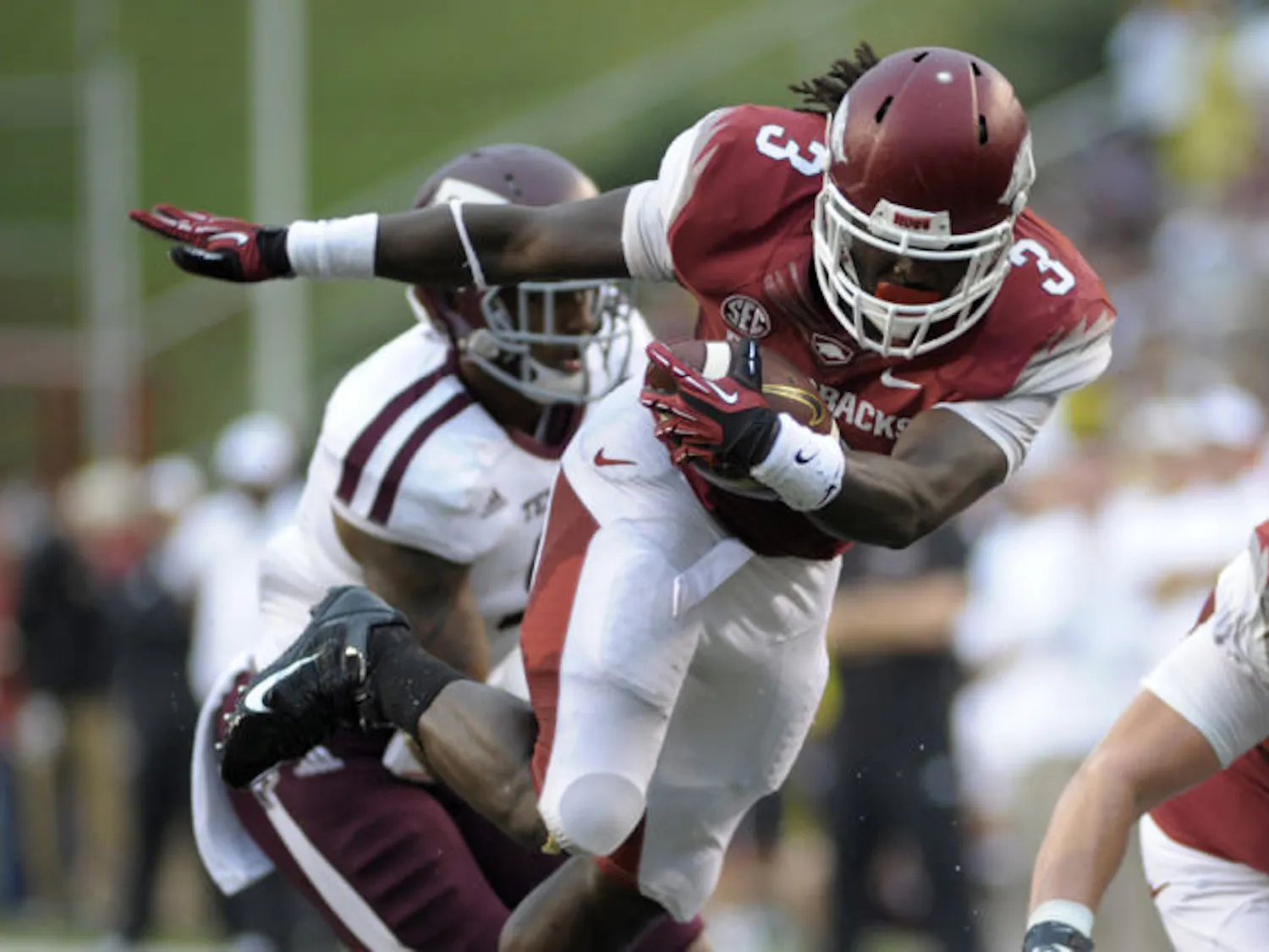 Arkansas tailback Alex Collins (3) runs past Texas A&M linebacker Nate Askew during the first quarter of a 45-33 loss to the Aggies on Saturday in Fayetteville, Ark. Collins is second in the Southeastern Conference in rushing yards per game.