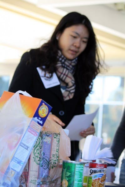 Angela Zhang collects canned food on the Reitz Union Colonnade on Friday during a food drive hosted by the the Center of Leadership and Service and The 15 percent.