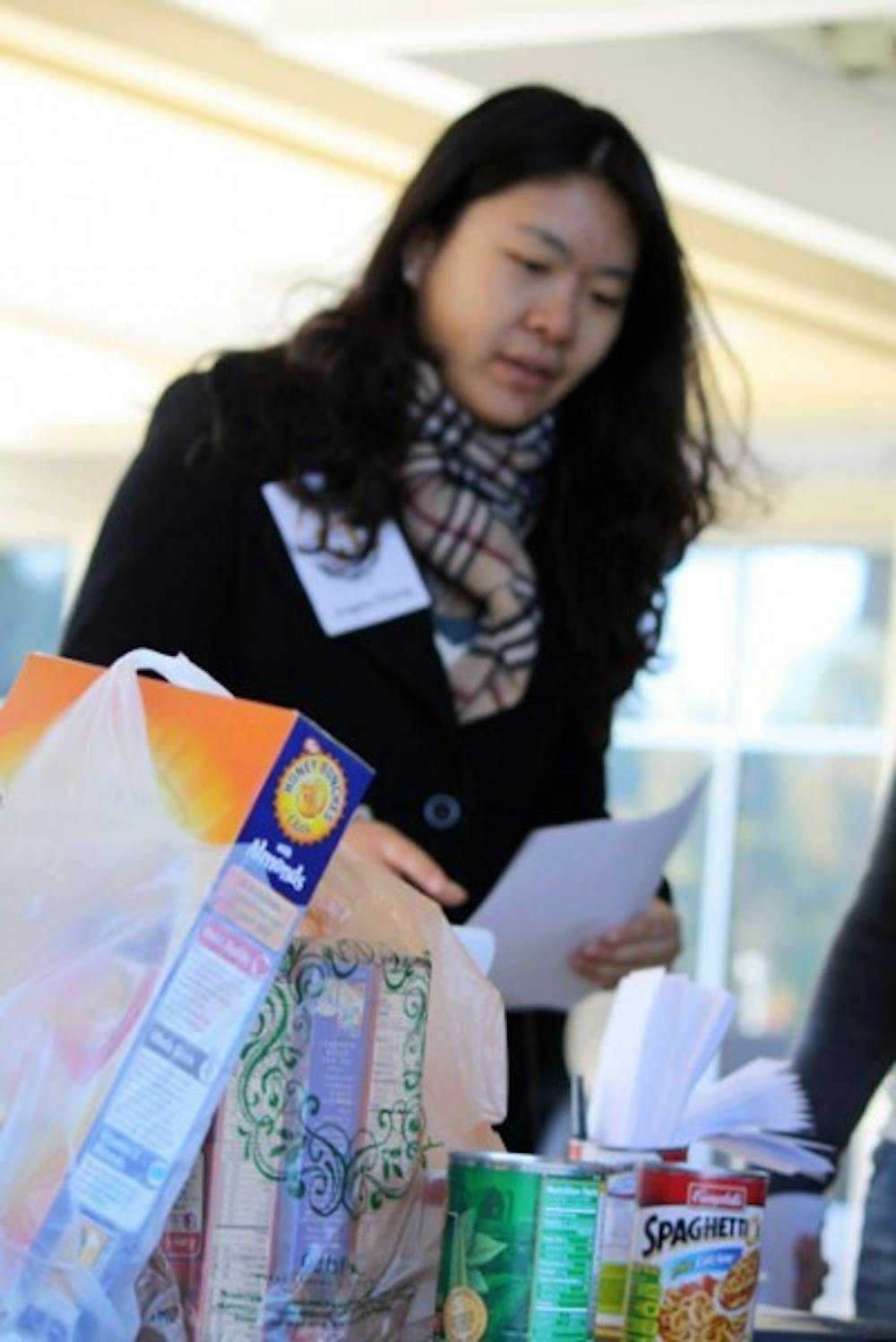 <p>Angela Zhang collects canned food on the Reitz Union Colonnade on Friday during a food drive hosted by the the Center of Leadership and Service and The 15 percent.</p>