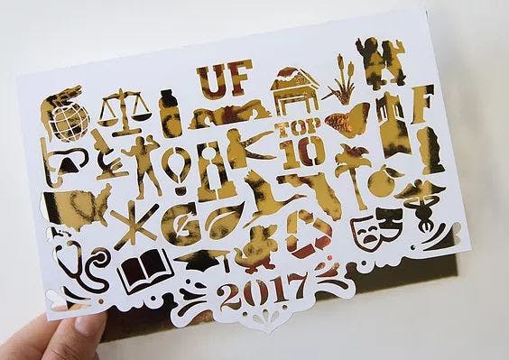 The winning card features 32 icons, which represent categories that make UF unique, cut out on white paper over gold foil. The message inside the winning card reads “Warmest Wishes,” which Jones described as a play on words about Florida’s hot weather.