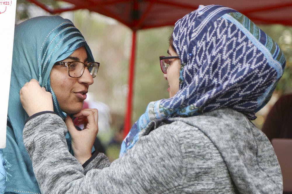 Samon Imtiaz, a 19-year-old UF biology sophomore, has a hijab put on by Mehreen Mahmood, a 21-year-old UF anthropology senior, on Turlington Plaza on February 16, 2016 as part of Islam on Campus' Islam Appreciation Month.