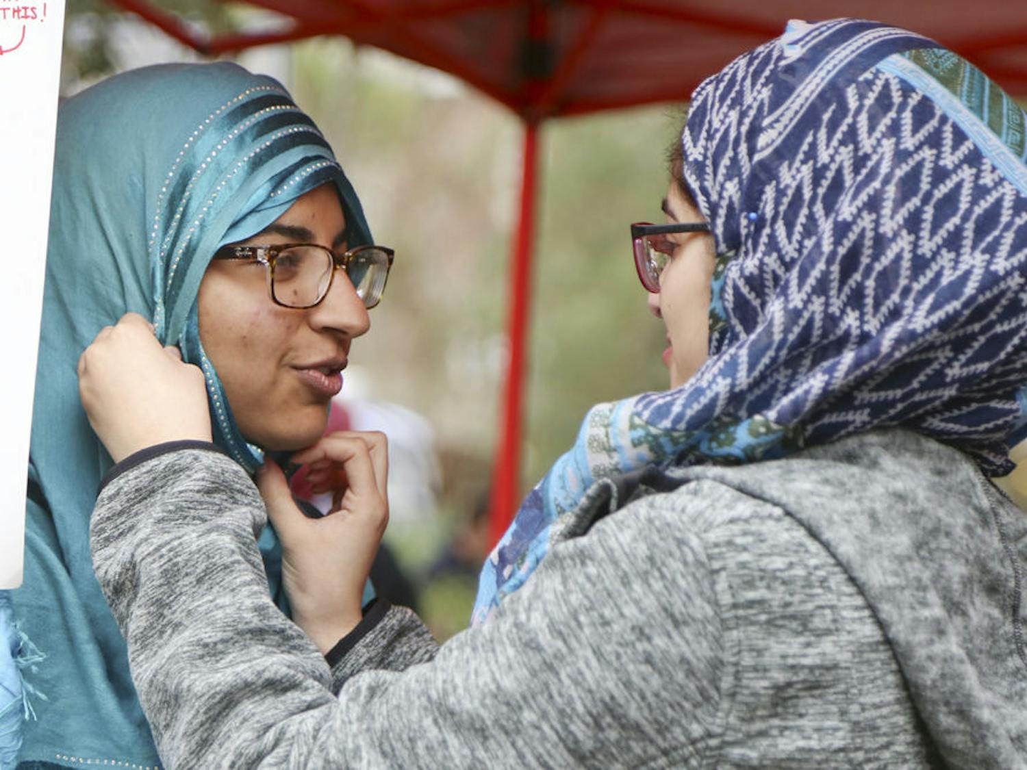 Samon Imtiaz, a 19-year-old UF biology sophomore, has a hijab put on by Mehreen Mahmood, a 21-year-old UF anthropology senior, on Turlington Plaza on February 16, 2016 as part of Islam on Campus' Islam Appreciation Month.