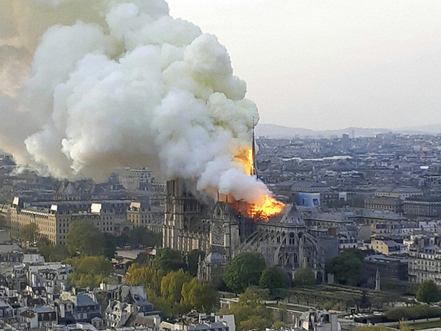 In this image made available on Tuesday April 16, 2019 flames and smoke rise from the blaze at Notre Dame cathedral in Paris, Monday, April 15, 2019. An inferno that raged through Notre Dame Cathedral for more than 12 hours destroyed its spire and its roof but spared its twin medieval bell towers, and a frantic rescue effort saved the monument's "most precious treasures," including the Crown of Thorns purportedly worn by Jesus, officials said Tuesday. (AP Photo/Cedric Herpson)