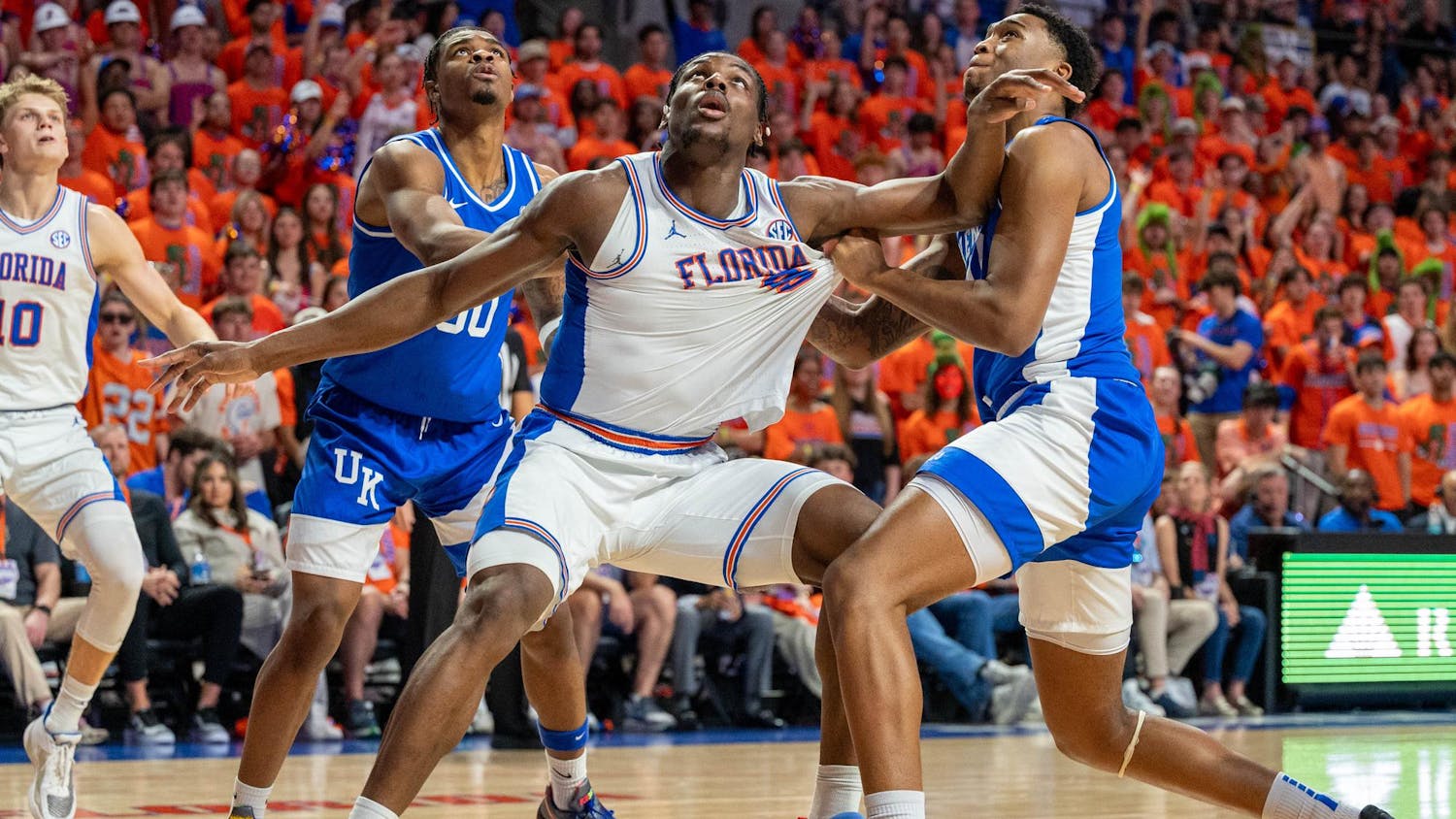 Florida center Rueben Chinyelu (9) reaches for the rebound against two Kentucky guards during the first half of an NCAA college basketball game, Saturday, Feb. 14, 2026 at Exactech Arena in Gainesville, Fla.