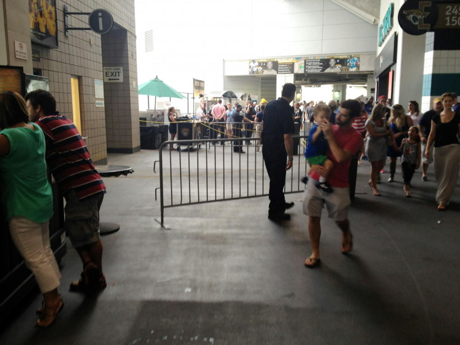 Spectators walk past a barricaded area where a fan fell on Saturday during the United States' 2-1 win against Nigeria at EverBank Field