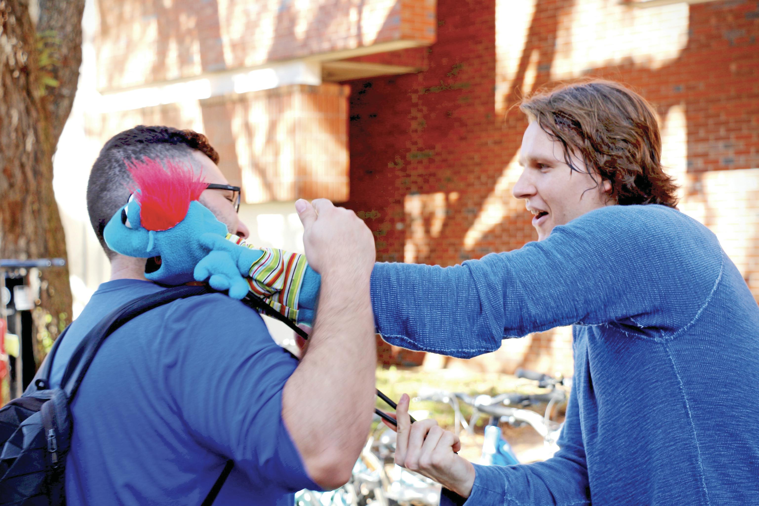Tyrone, a foul-mouthed puppet controlled by Hippodrome State Theatre actor Jon Kovach, hugs Sammy Dahan, a 21-year-old UF biology senior, on Turlington Plaza on Wednesday. 