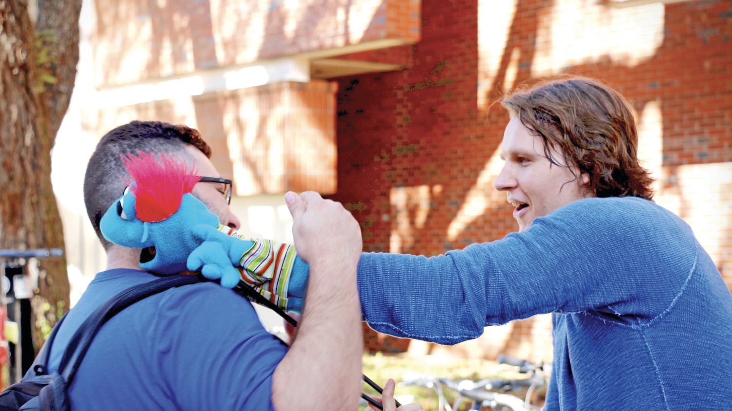 Tyrone, a foul-mouthed puppet controlled by Hippodrome State Theatre actor Jon Kovach, hugs Sammy Dahan, a 21-year-old UF biology senior, on Turlington Plaza on Wednesday.