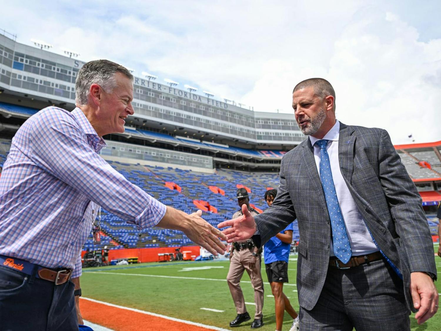 Florida Gators head coach Billy Napier shakes athletics director Scott Stricklin’s hand before a football game between the Texas Longhorns and the Florida Gators on Saturday, Oct. 4, 2025, at Ben Hill Griffin Stadium in Gainesville, Fla.