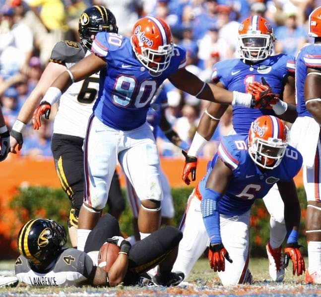 Freshmen Jonathan Bullard (90) and Dante Fowler Jr.&nbsp; (6) celebrate a stop of Missouri tailback Kendial Lawrence (4) during UF’s 14-7 win on&nbsp;Nov. 3&nbsp;in The Swamp.&nbsp;