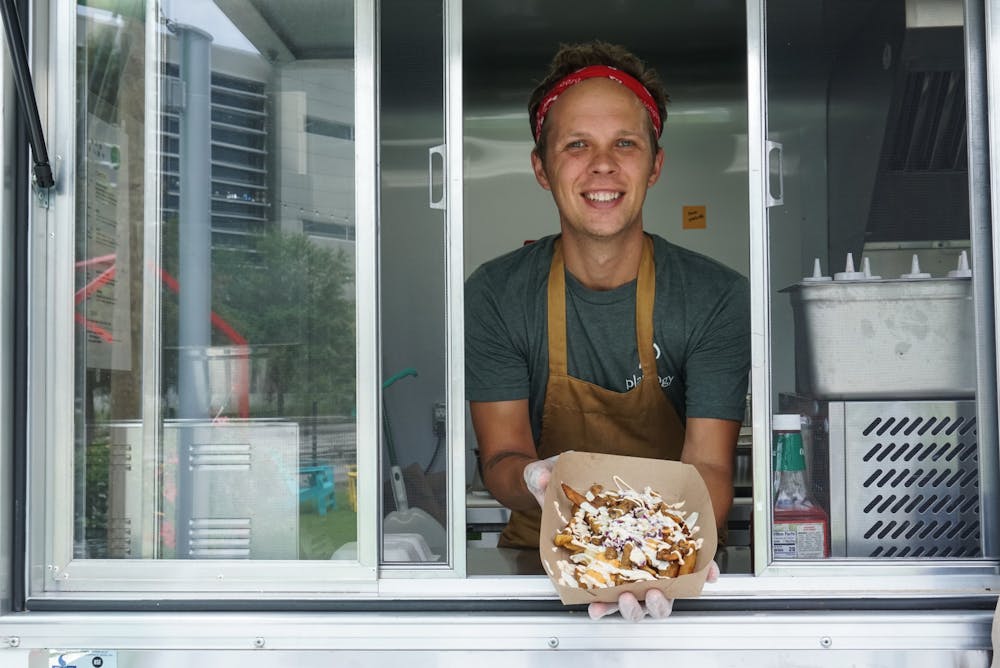 Ryan Strandjord, 37, displays Plantology’s loaded fries at the restaurant’s food truck, located at Midpoint Park and Eatery in the 900 block of Southwest Second Avenue, on Friday, July 2, 2021. 