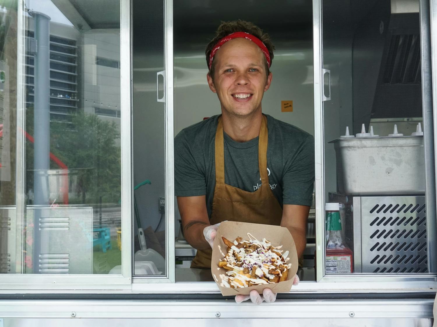 Ryan Strandjord, 37, displays Plantology’s loaded fries at the restaurant’s food truck, located at Midpoint Park and Eatery in the 900 block of Southwest Second Avenue, on Friday, July 2, 2021. 