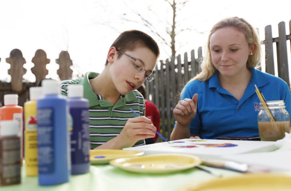 <p>Michael Sayeski, 13, and Alexis Coryell, a 22-year-old UF finance senior, paint ice cream-themed artwork at Sweet Dreams’ new location, 1040 E. University Ave., on Monday in support of Dance Marathon.</p>