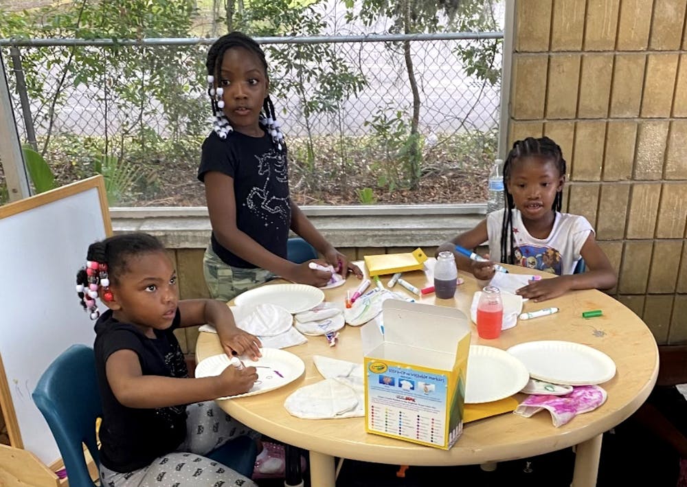 <p>(From left to right): Sereniti Miller, Seyvyer Miller and Aariona Williams keep themselves busy with arts and crafts at Wash King on Tuesday, March 28, 2023.</p>