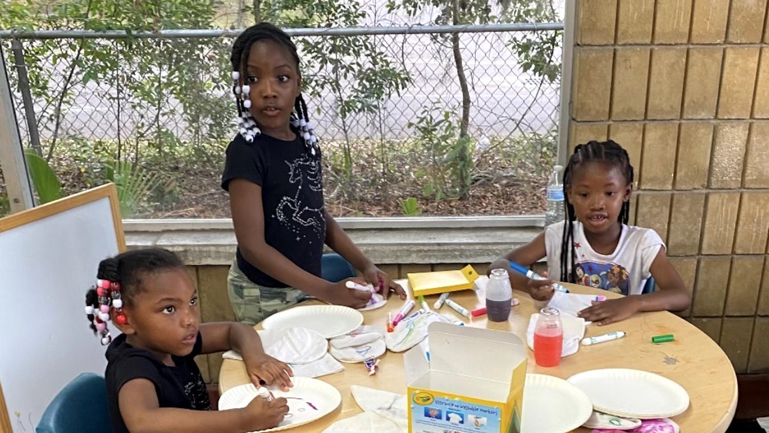 (From left to right): Sereniti Miller, Seyvyer Miller and Aariona Williams keep themselves busy with arts and crafts at Wash King on Tuesday, March 28, 2023.