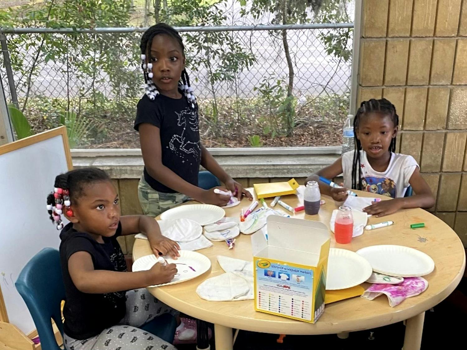 (From left to right): Sereniti Miller, Seyvyer Miller and Aariona Williams keep themselves busy with arts and crafts at Wash King on Tuesday, March 28, 2023.