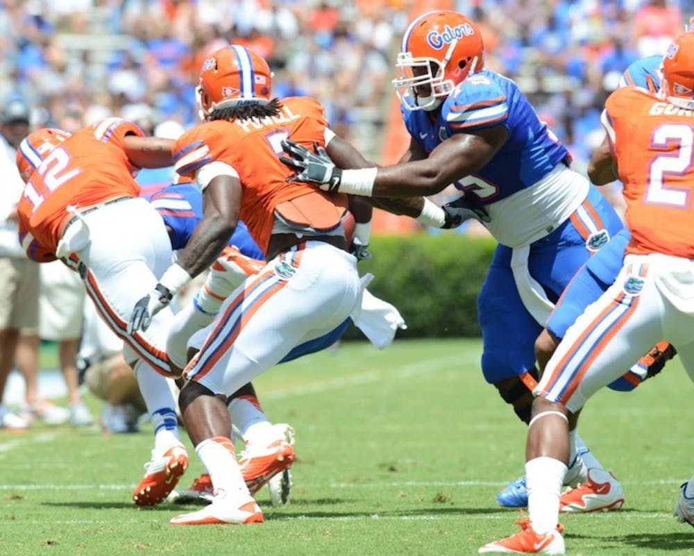 <p>Junior Ronald Powell (7) is pushed by right tackle Chaz Green during Saturday’s spring game. Powell fell to the turf after being pushed and suffered a torn ACL in his left knee. He is out at least four months.</p>