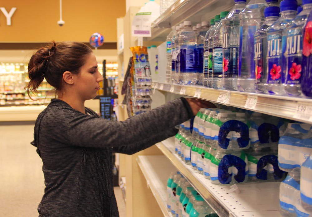 Haley Ehrlich, a 21-year-old UF anthropology and classical studies senior, buys some of the remaining cases of water at Publix to bring to her family in Jacksonville on Wednesday afternoon. According to Ehrlich, when her family tried to buy water in Jacksonville, it was sold out. “I just don’t know how much to bring,” she said, pulling water from the shelf. 