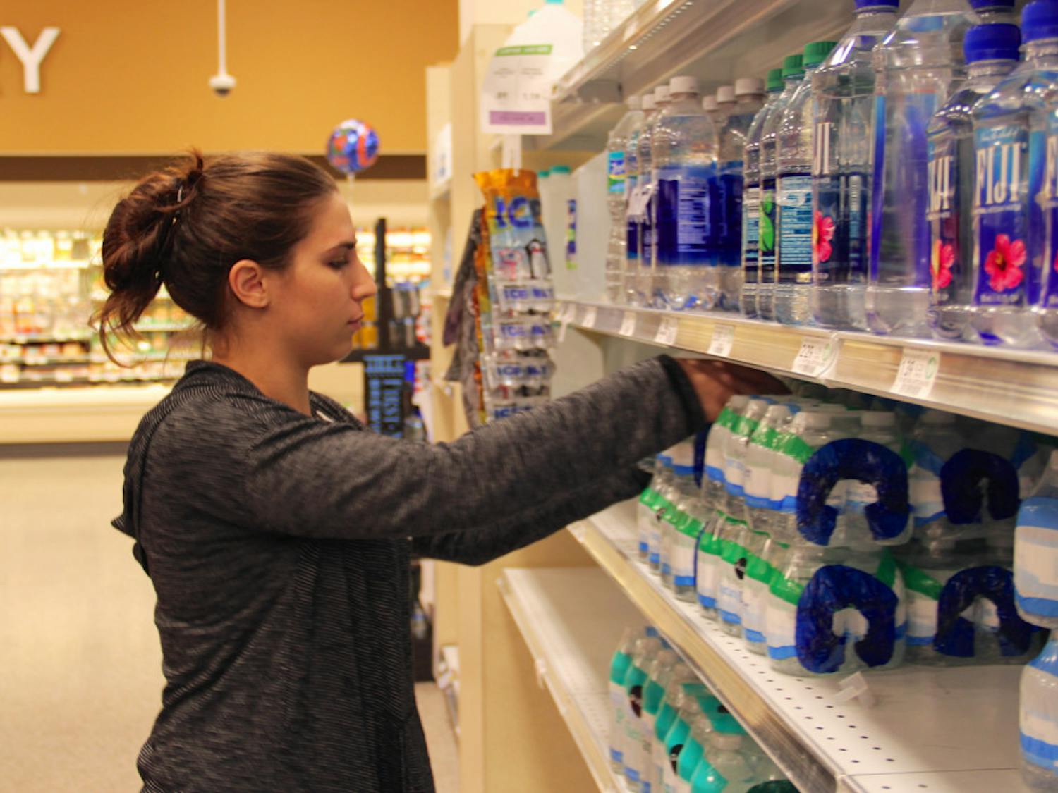 Haley Ehrlich, a 21-year-old UF anthropology and classical studies senior, buys some of the remaining cases of water at Publix to bring to her family in Jacksonville on Wednesday afternoon. According to Ehrlich, when her family tried to buy water in Jacksonville, it was sold out. “I just don’t know how much to bring,” she said, pulling water from the shelf.