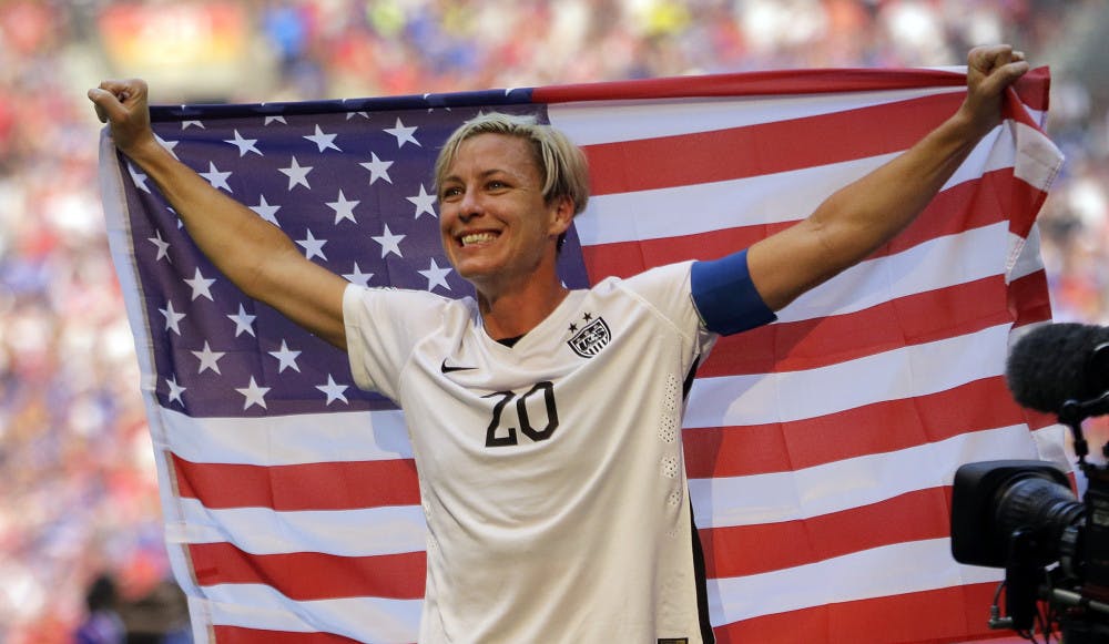 In this July 5, 2015, file photo, United States' Abby Wambach holds an American flag after the U.S. beat Japan 5-2 in the FIFA Women's World Cup soccer championship in Vancouver, British Columbia, Canada. Wambach, the leading career scorer, male or female, in international soccer, announced her retirement from soccer on Tuesday, Oct. 27, 2015, shortly after the U.S. national team celebrated its Women's World Cup victory at the White House. (AP Photo/Elaine Thompson, File_