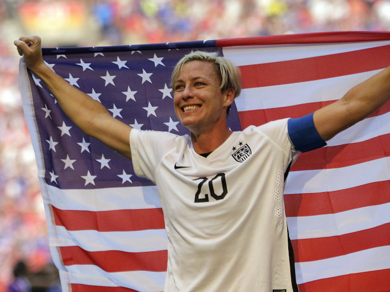 In this July 5, 2015, file photo, United States' Abby Wambach holds an American flag after the U.S. beat Japan 5-2 in the FIFA Women's World Cup soccer championship in Vancouver, British Columbia, Canada. Wambach, the leading career scorer, male or female, in international soccer, announced her retirement from soccer on Tuesday, Oct. 27, 2015, shortly after the U.S. national team celebrated its Women's World Cup victory at the White House. (AP Photo/Elaine Thompson, File_