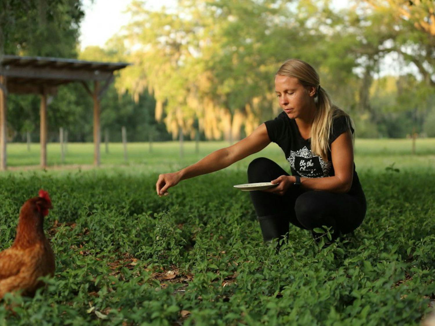 Emma Hoel, co-founder of Peacefield, feeding Bernadette, one of the chickens living at Peacefield.