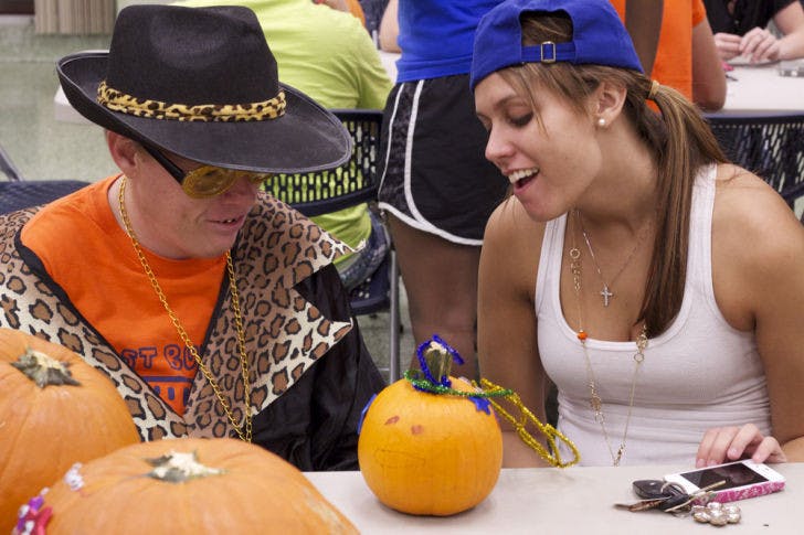 UF criminology freshman Deirdre Pearsall, 18, helps Gainesville resident Chris Brown, 34, decorate a pumpkin for the party hosted by Best Buddies at the Broward Hall Basement on Wednesday evening.