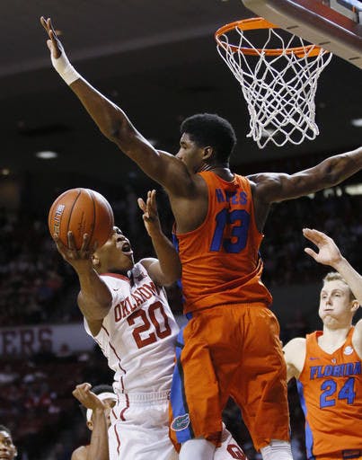 Florida forward Kevarrius Hayes (13) defends as Oklahoma guard Kameron McGusty (20) shoots in the second half of an NCAA college basketball game in Norman, Okla., Saturday, Jan. 28, 2017. Florida won 84-52. (AP Photo/Sue Ogrocki)