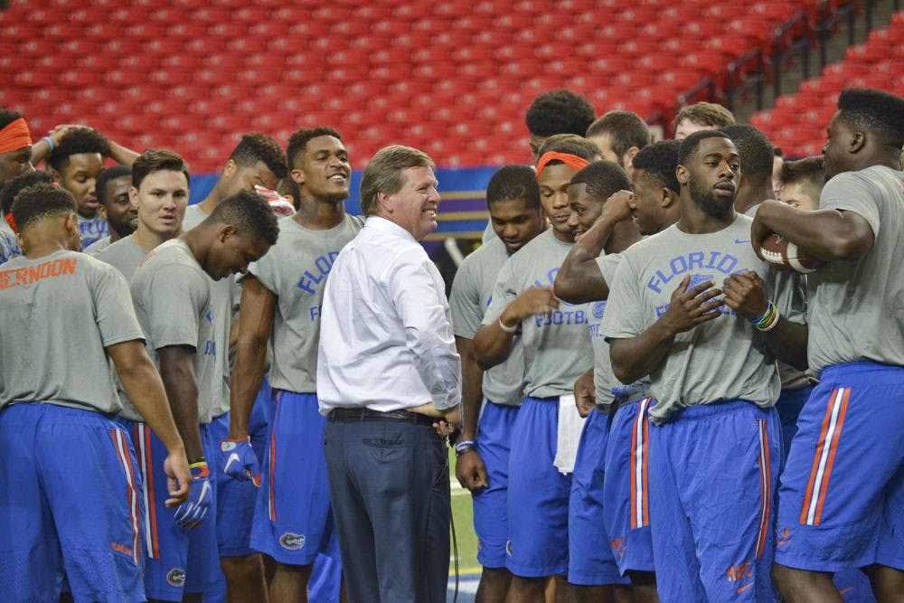 <p>UF coach Jim McElwain smiles in the huddle during practice on Dec. 4, 2015, at the Georgia Dome in Atlanta.</p>