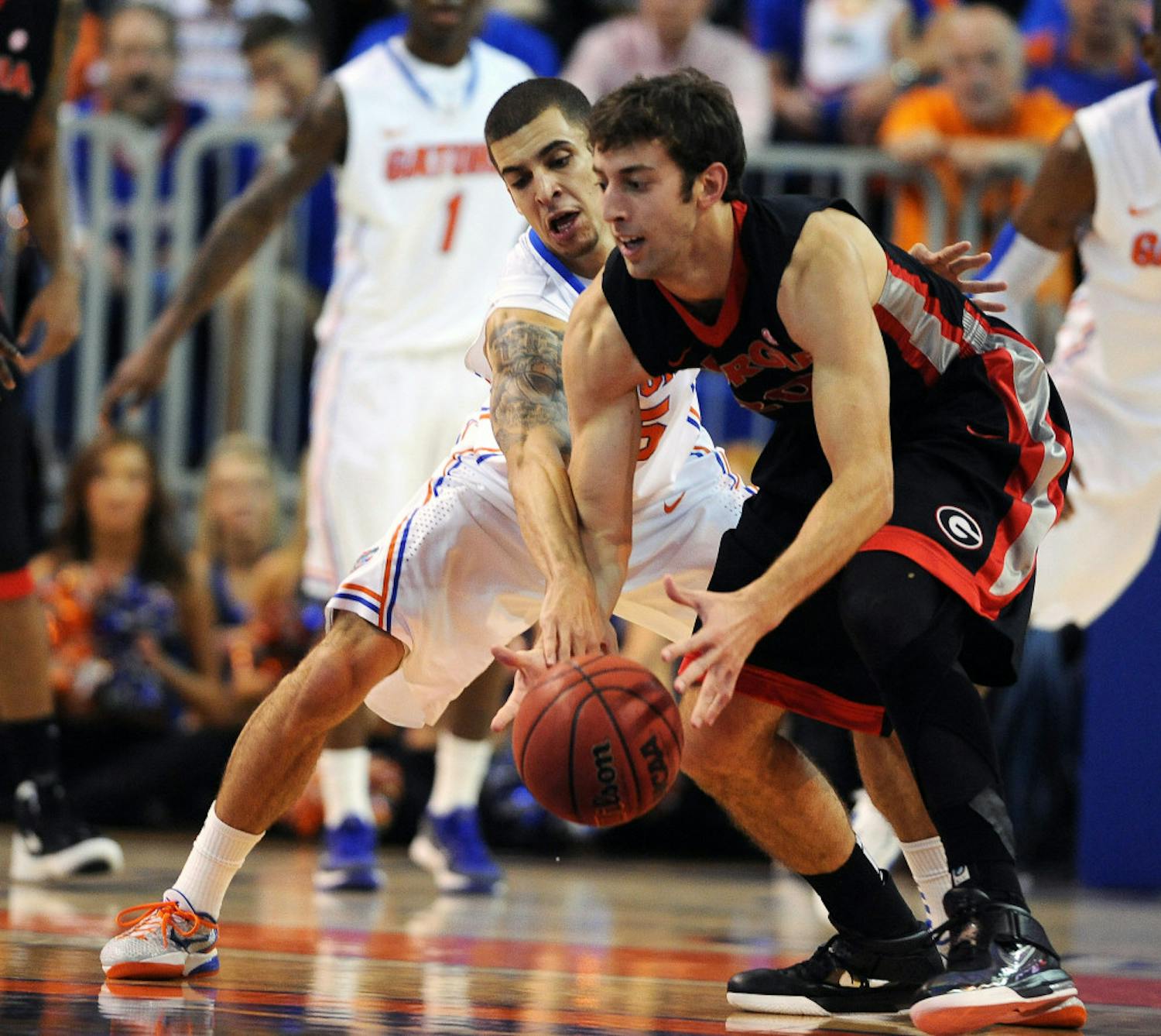 Florida's Scottie Wilbekin (5) tries to break the ball lose from
Georgia's Connor Nolte (20) during the first half of an NCAA
college basketball game in Gainesville, Fla., Tuesday, Jan. 10,
2012.