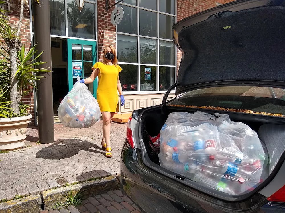 <p>Iryna Kanishcheva holds recycled bottles in front of Black C Art Gallery. (Photo courtesy of Black C Art Gallery by Ani Collier)</p>