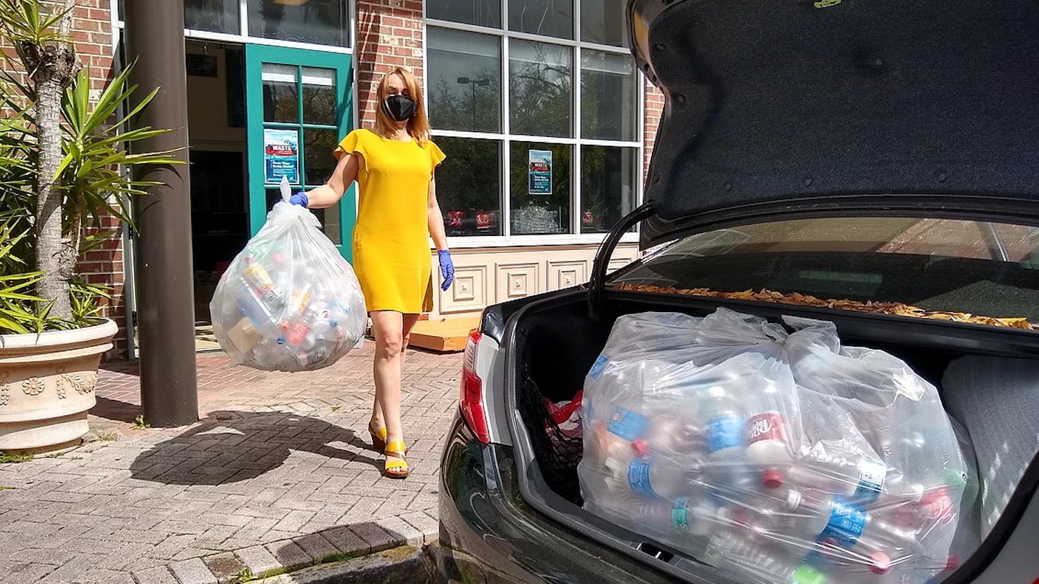 Iryna Kanishcheva holds recycled bottles in front of Black C Art Gallery. (Photo courtesy of Black C Art Gallery by Ani Collier)