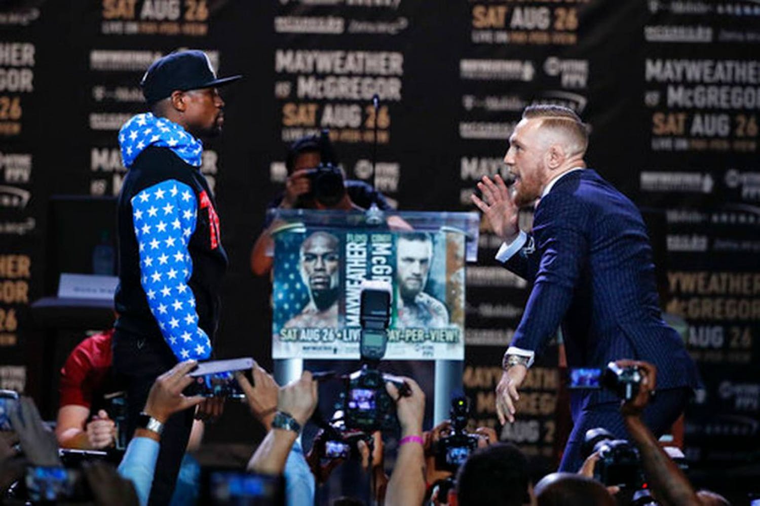 Conor McGregor (right) taunts Floyd Mayweather Jr. while posing for photos during a press conference on July 11, 2017, in Los Angeles.
