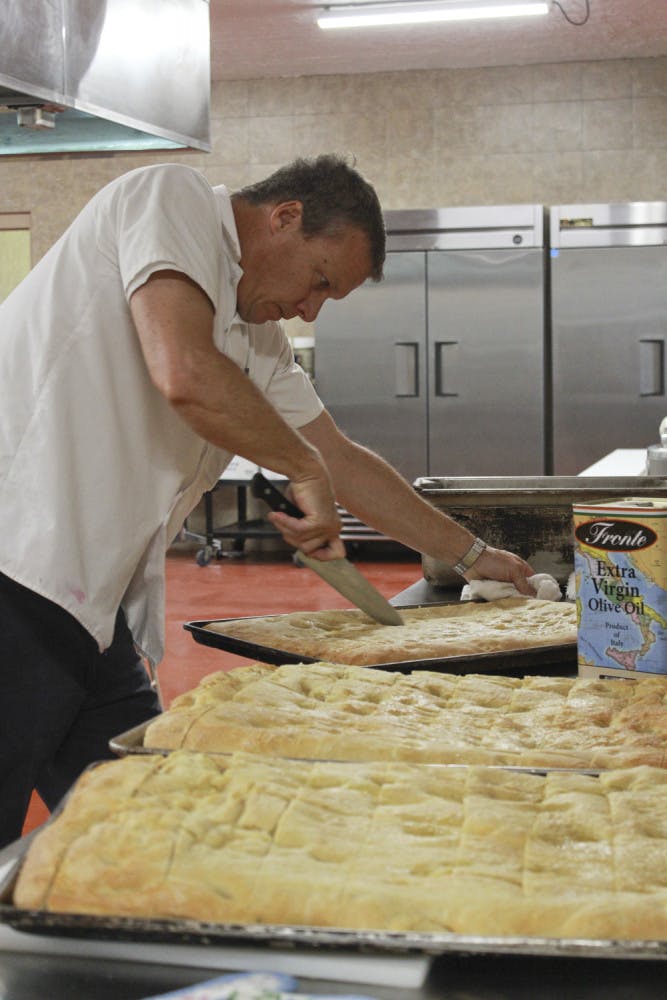 Grace Marketplace volunteer Bert Gill, 46, cuts bread into smaller portions after removing it from one of the new ovens on Nov. 14, 2015. “It will be so much easier to feed so many more people,” he said.