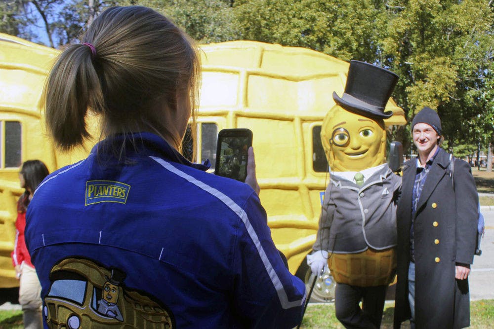 Liz Johnson, a 23-year-old "peanutter" who travels with the Planters NUTmobile, photographs Mr. Peanut and Billy Schap, a 22-year-old UF astronomy senior, near Plaza of the Americas on Thursday.