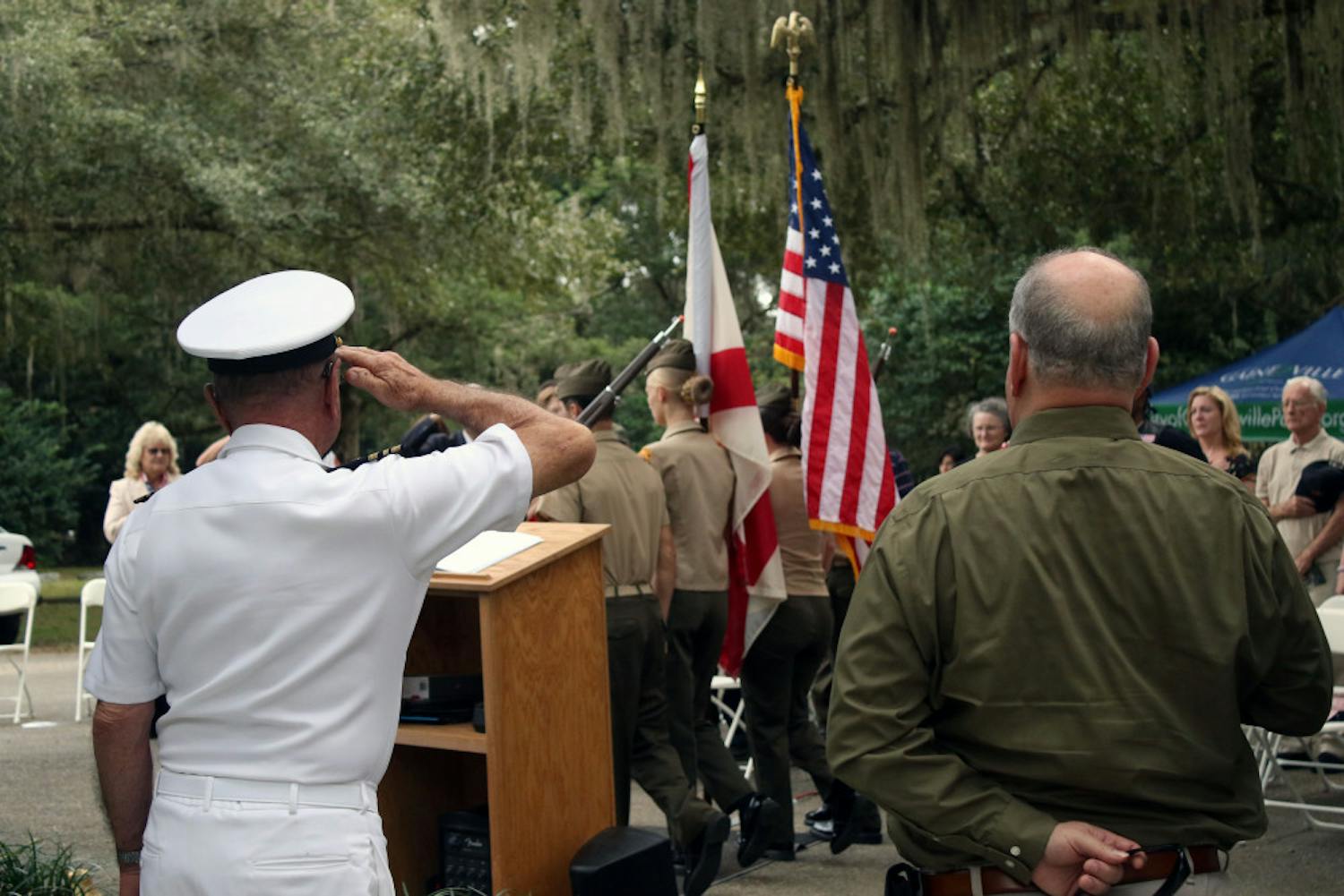 Retired Lt. Commander Gary Cook (L) salutes the flag as the Milton Lewis Young Marines present the colors at a Veterans Day event at Evergreen Cemetery in Gainesville on Monday, Nov. 12, 2018. The event was held to honor the veterans buried in the cemetery and to commemorate the 100th anniversary of the end of World War One.