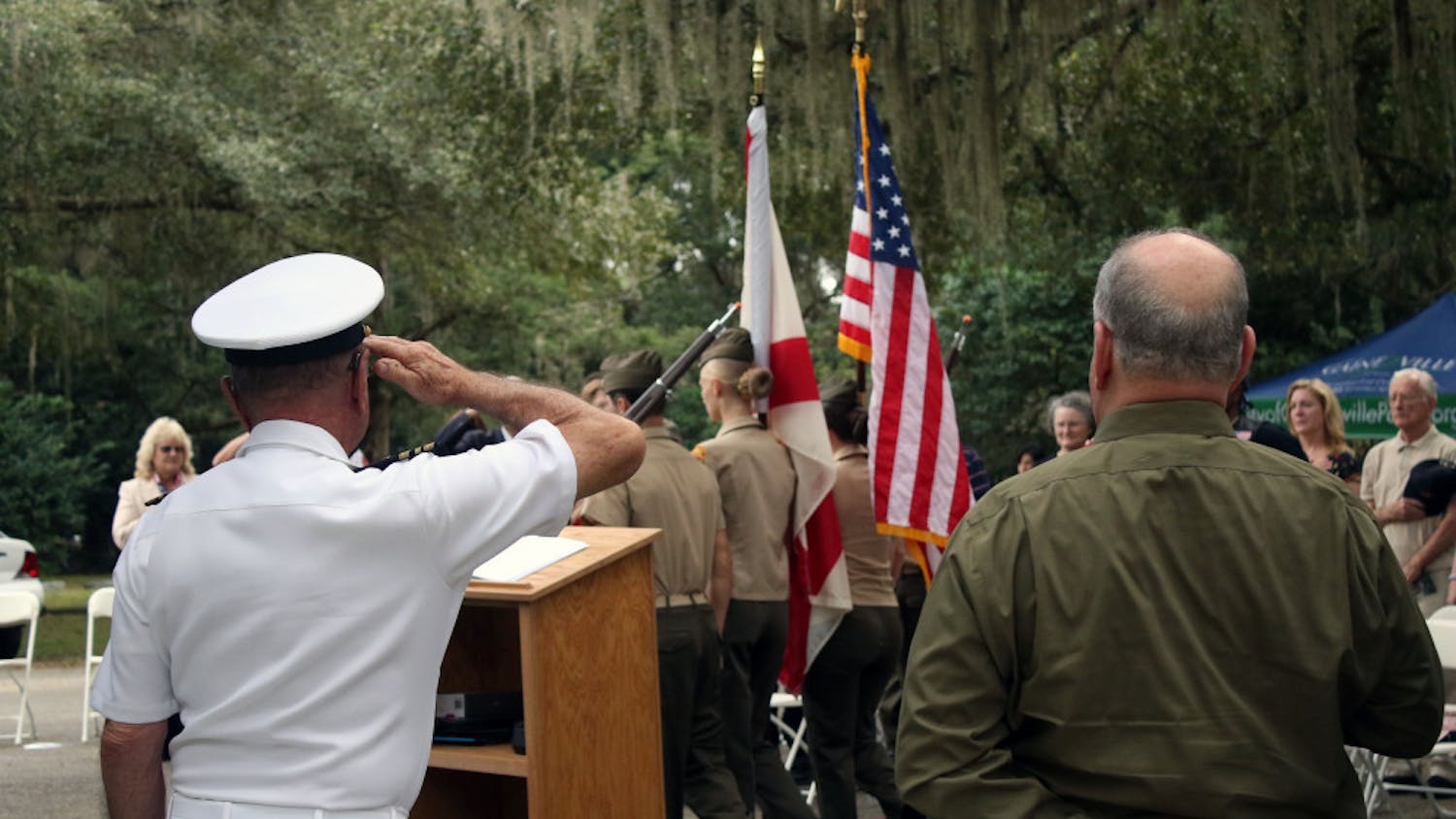 Retired Lt. Commander Gary Cook (L) salutes the flag as the Milton Lewis Young Marines present the colors at a Veterans Day event at Evergreen Cemetery in Gainesville on Monday, Nov. 12, 2018. The event was held to honor the veterans buried in the cemetery and to commemorate the 100th anniversary of the end of World War One.