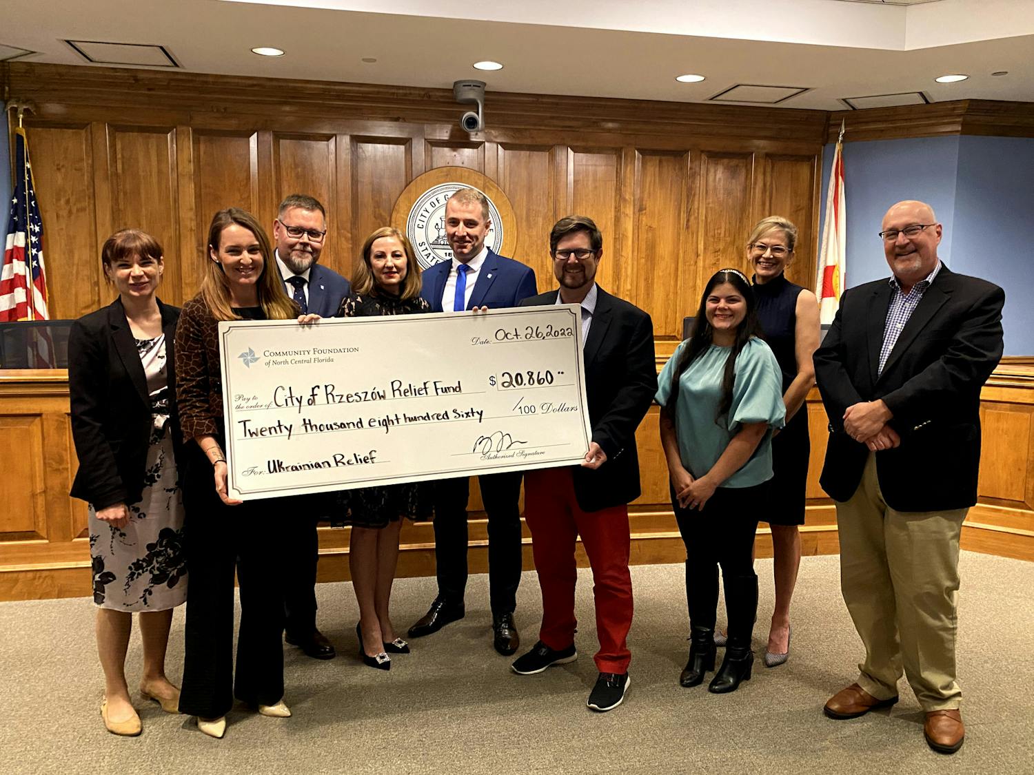 Delegates from Poland accept $20,860 presented to them by Mayor Lauren Poe and Commissioners Reina Saco and Harvey Ward, Oct. 26, 2022.