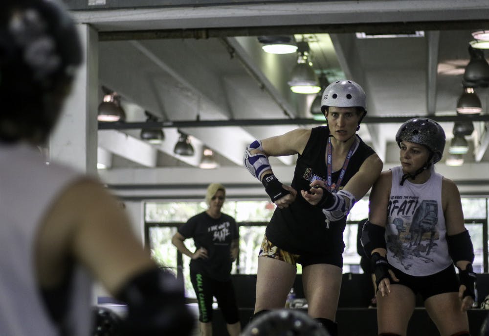 Hillary Buscovick, a 31-year-old professional roller derby skater, works with Lizz Zieschang, 28, to demonstrate blocking techniques at a workshop for local skaters at the Alachua County Fairgrounds on Saturday. “I want every skater and athlete to be the best they can be,” Buscovick said. Buscovick, who goes by Scald Eagle when playing, has played competitively since 2011 and currently plays for the Denver Roller Derby Mile High Club team. 