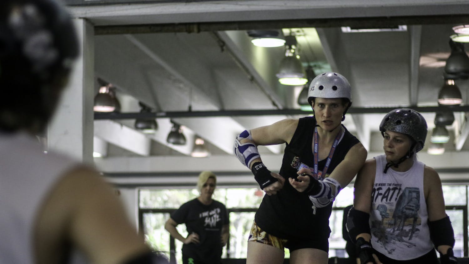 Hillary Buscovick, a 31-year-old professional roller derby skater, works with Lizz Zieschang, 28, to demonstrate blocking techniques at a workshop for local skaters at the Alachua County Fairgrounds on Saturday. “I want every skater and athlete to be the best they can be,” Buscovick said. Buscovick, who goes by Scald Eagle when playing, has played competitively since 2011 and currently plays for the Denver Roller Derby Mile High Club team.